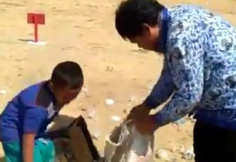 Seorang pria di bantu seorang anak kecil peduli bersihkan sampah usai upacara HUT RI