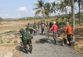 Warga Bersama Satgas TMMD Meratakan Batu Seplit 