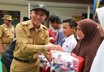 Bupati Lambar saat menyerahkan seragam gratis untuk siswa SD dan SMP