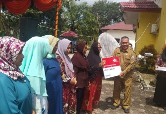 Sekda Aceh Singkil Drs.Azmi saat menyerahkan lounching perdanan Bantuan Pangan Non Tunai (BPNT) bagi sipenerima.