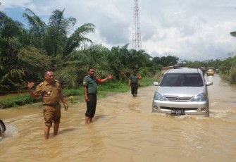 Danramil 09/NL Kapten Sofyan Sukri Bantu Warga Melintas Jalan Yang Terendam Banjir 