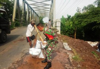Warga dibantu personel TNI pertebal Tanggul Babakan