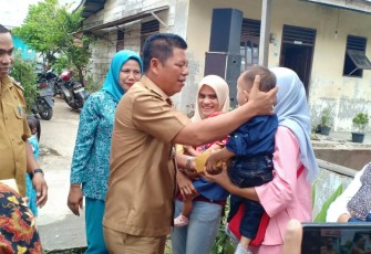 Camat Rantau Utara Turing Ritonga saat membagikan hadiah kepada ibu-ibu yang aktif membawa balitanya ke posyandu