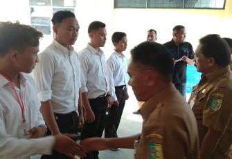 Bupati Batu Bara Ir Zahir M.AP diwakili Asisten I Rusian Heri didampingi oleh Kadisnaker Erinaldo saat memberikan buku panduan.