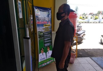 Salah seorang petugas Disdikbud Aceh Singkil saat melakukan mengukur suhu tubuh dialat pengukur didepan Kantor Dinas terkait.