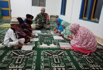 Babinsa Koramil 1905/Jatiluhur Kodim 0619/Purwakarta Serka Maman Suparman Saat Sedang Mengajari Anak-anak Desa Cibinong Membaca dan Menghafal Al-Quran (Foto/Aik NH)