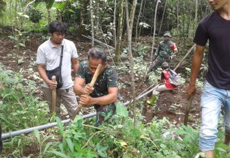 Anggota Koramil 10/Mrebet bersama masyarakat  Dusun V Desa Pengalusan Kecamatan Mrebet bahu-membahu melaksanakan pipanisasi untuk jalur distribusi air , Rabu, (18/11/2020).