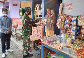 Babinsa Kelurahan Sewu Koramil 04/Jebres Kodim 0735/Surakarta Serka Suryanto.membagi-bagikan masker dan sabun kepada warga di RW 8 wilayah Kelurahan Sewu, Sabtu, (23/1/2021).