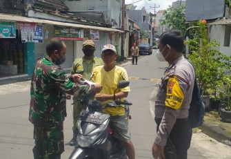 Babinsa Kelurahan Kemlayan Koramil 03 Serengan Kodim 0735 Surakarta Serka A. Rumbawa bersama Bhabinkamtibmas Aiptu Sarjono dan Linmas membagikan masker kepada warga yang melintas di  kampung Darpoyudan RT 02 RW 03 Kelurahan Kemlayan Kec. Serengan Kota Surakarta.