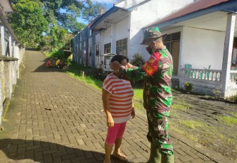 Dan SSK TMMD Lettu INF Jullen Tonny Kasiaheng saat berbagai masker dan memasangkan masker kepada salah satu warga yang melintas dan tak gunakan masker