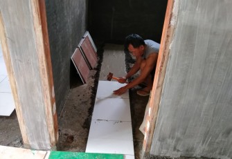 Personil satgas TMMD Kodim 1310/Bitung saat mengerjakan pemasangan tehel