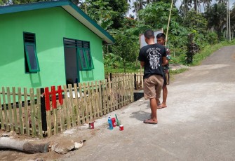 Personil satgas TMMD melakukan pengecetan pagar RTLH Milik Opa Daniel