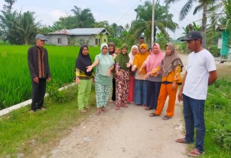 Ibu-ibu, warga setempat memperlihatkan jalan yang rusak dan berharap segera diperbaiki.