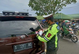 Petugas pasang stiker Kamseltibcarlantas dan Prokes