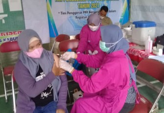 Salah seorang warga yang sedang menjalani vaksinasi