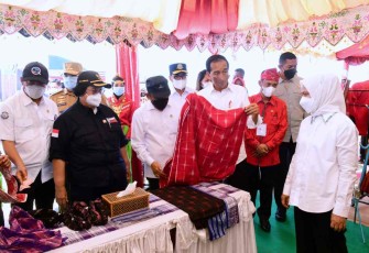 Presiden RI Joko Widodo saat mencoba kain tradisional di salah satu stand UMKM