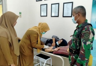 Sertu Syarif saat dampingi warga Binaannya pasang KB di puskesmas. Senin (19/9)