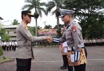 Kapolres Malang AKBP Putu Kholis Aryana saat memberikan penghargaan anggotanya yang berprestasi. Sabtu (17/12)