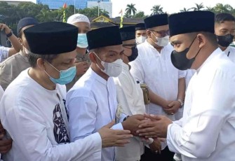 Suwarno (masker hitam) saat bersalam-salaman usai shalat Ied di lapangan Merdeka Medan. Senin (02/05/2022)