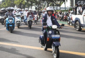 Pj Gubernur DKI Jakarta Heru Budi Hartono saat mengendarai motor listrik Vespa di Jakarta 