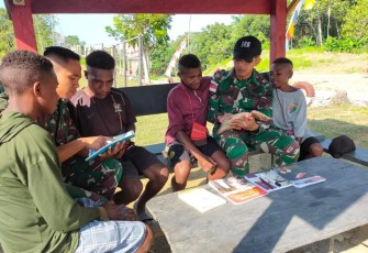 Personel Satgas Yonif 126/Kala Cakti Pos KM140 saat ajarkan membaca dan menulis bagi anak-anak 