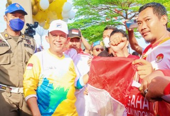 Ansar saat Bagikan Bendera merah puti pada warga