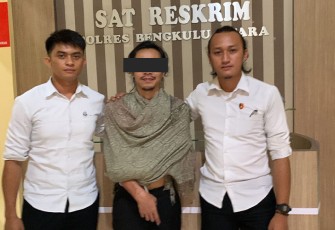 Terduga pelaku (tengah) saat diamankan polisi