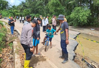 Kapolsek Batang Toru, AKP Tona Simanjuntak, SH, meninjau Ruas Jalan Lintas Barat yang terputus akibat meluapnya air Sungai Malombu, Selasa (14/11/2023)