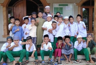 Bhabinkamtibmas Polsek Batang Toru, Aiptu Sayaman Siregar, berikan motivasi ke siswa Madrasah Diniyah agar cepat bisa baca tulis Al Quran, Kamis (3/8/2023) sore.