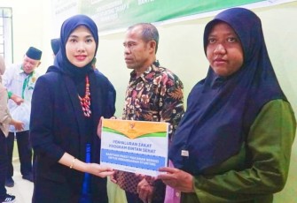 Ketua TP PKK Bintan Hafizha Rahmadhani saat melakukan pendistribusian Zakat melalui Baznas Kabupaten Bintan.