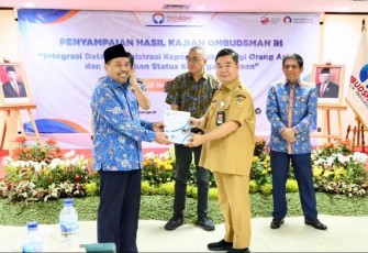 Ketua Ombudsman Muhammad Najih menyerahkan hasil kajiannya kepada Dirjen Dukcapil Teguh Setyabudi di kantor Ombudsman, Jakarta, Selasa (28/11/2023). (Foto: Dukcapil/Satrio) 