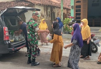 Serma Sukan Yusuf membagikan sayuran hasil panen dari kebun hidroponik yang berada di halaman Koramil kepada masyarakat.