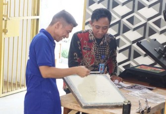 Warga binaan lapas Cilegon saat mengerjakan printing kaos, Senin (10/7)