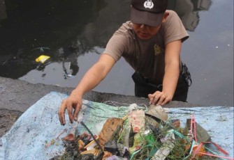 Personel Polda Sulsel Bersihkan Sampah di kanal pasar Terong, Kota Makassar, Kamis (13/7)