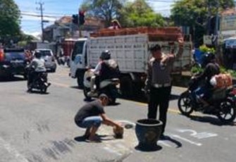 Bripka Agus Setiawan bersama masyarakat saat tambal jalan