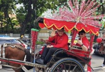 Sekjen PDIP Hasto Kristianto menaiki andong saat daftar caleg ke KPU di Jakarta, Kamis (11/5)