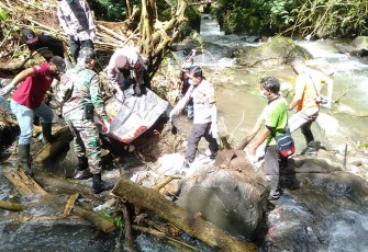 Petugas saat sedang berupaya mengevakuasi tubuh jasad manusia yang ditemukan di aliran sungai air terjun di kawasan Taman Wisata Alam Grojogan Sewu, Tawangmangu, Karanganyar, Jumat (24/2/2023).