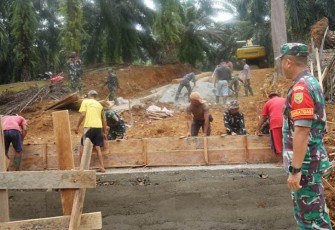 (Dansatgas Letkol Inf. Aswin Suladi, saat meninjau pembangunan infrastruktur jembatan, memastikan kebutuhan material dan pekerjaan lancar)