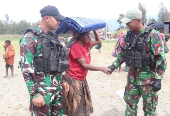 Satgas Yonif 330 Tri Dharma saat Bagikan Terpal Untuk Warga Kampung Bazemba
