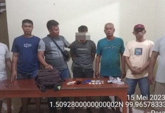 Tersangka Em saat diamankan personel Polsubsektor Simangambat