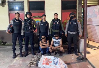 Tersangka (jongkok diborgol) saat diamankan