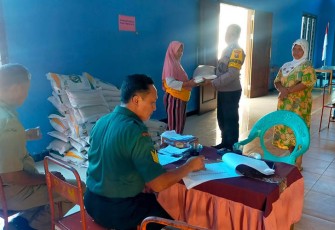 Pakis Serma Teguh anggota Koramil 0806/03 Durenan yang turut berperan aktif dalam kegiatan penyerahan bantuan pangan beras kepada warga kurang mampu, Senin (11/12/2023)