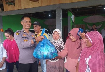 Bripka Hendri Putra Sekta saat menyalurkan bantuan langsung ke warga terdampak banjir.