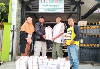 Ketua Komunitas Jurnalis Depok Jhon Anis saat menerima nasi box dari Yayasan Iman Taqwa, Depok, Selasa (12/3)