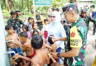 Ketua Tim Wasev TMMD ke-120 Kodim 0209/LB Kolonel Inf Parluhutan Marpaung saat melihat kegembiraan anak-anak desa Selat Beting dengan air bersih sumur bor program unggulan Kasad. Jum'at (31/5)