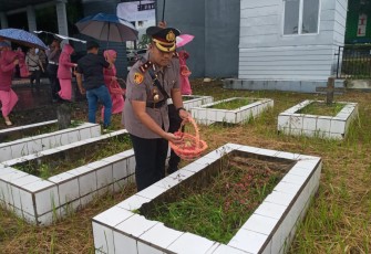 Wakapolres Bitung Kompol Aprizal Nugroho saat menaburkan bunga di salah satu makam pahlawan