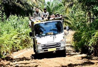 Antusias warga bersama Satgas TMMD gunakan truk lintasi jalan yang sudah selesai diperkeras.
