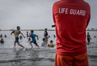 Wisatawan menikmati deru ombak di pantai 