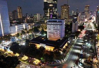 Ilustrasi gedung perkotaan dengan pasokan listrik di malam hari 
