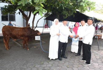 Danlantamal V Brigjen TNI (Mar) Joni Sulistiawan, S.H., M.Han., didampingi Ketua Korcab V DJA II Ny Heny Joni Sulistiawan saat menyerahkan secara simbolis hewan kurban kepada Ketua Panitia Idul Adha Lantamal V, Letkol Laut (P) Ali Sodikin.